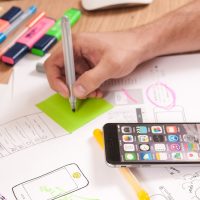 免费抠图 在线 编辑团队成员头像：一位编辑在便签墙前整理用户提问卡片，墙面贴满手写问题，暖色灯光营造工作氛围